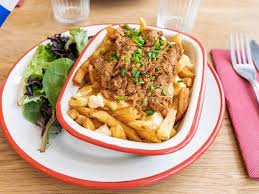 Picture of people sharing a bowl of poutine and smiling